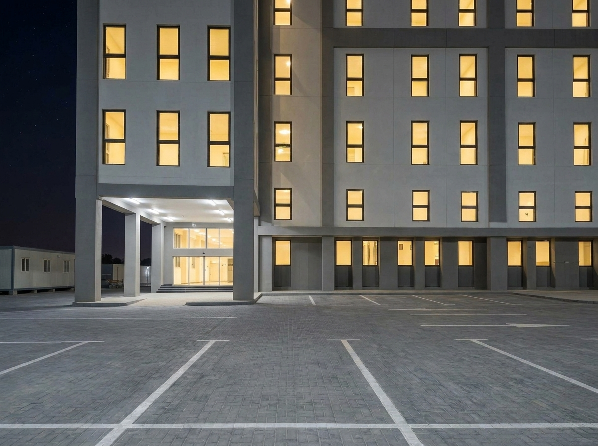 Modern workforce accommodation building exterior at night